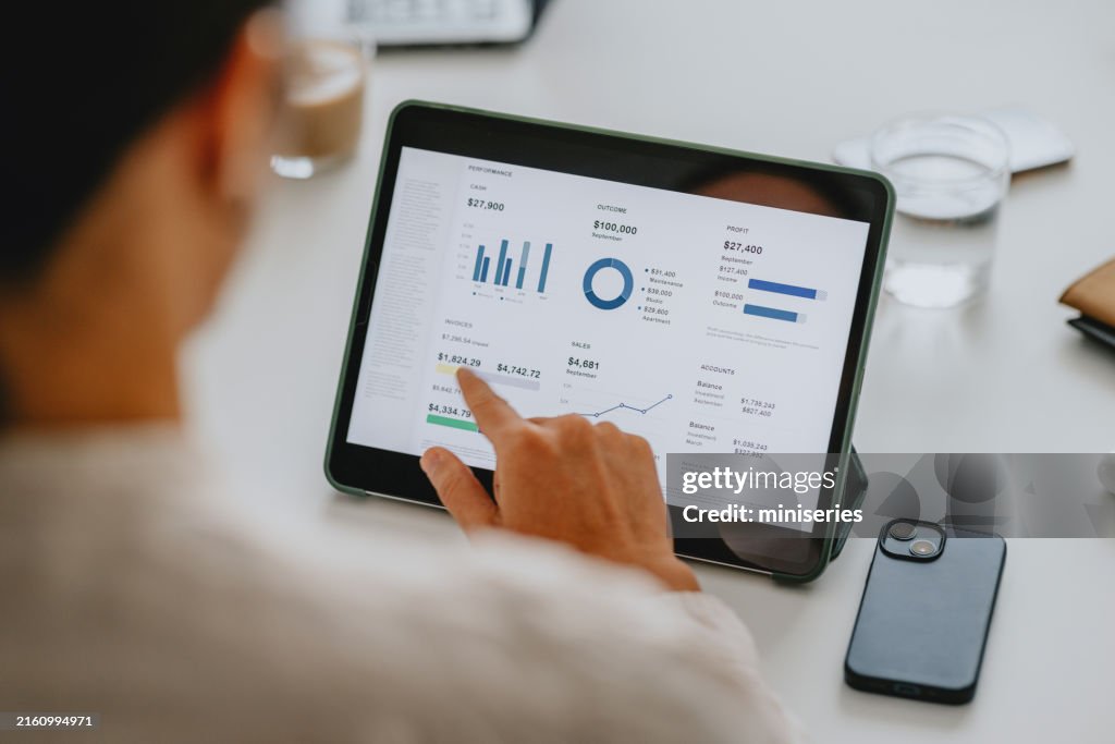 Business Analyst Reviewing Financial Data on Tablet in Office