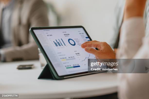 business-team, das während des meetings daten auf einem digitalen tablet analysiert - visuelle darstellung stock-fotos und bilder