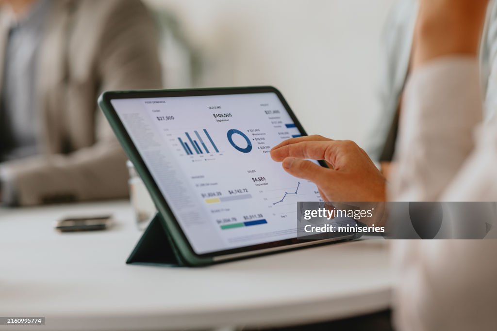 Business Team Analyzing Data on Digital Tablet During Meeting