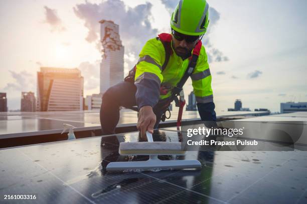 male engineer are working at high rooftop for cleaning photovoltaic panel system. - lucht en ruimtevaartingenieur stockfoto's en -beelden
