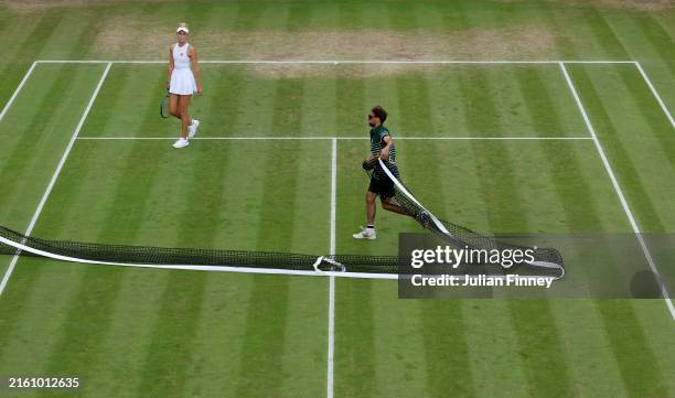 Erin Routliffe of New Zealand looks on as the net is removed before the covers are brought on as rain delays play on Court No.18 during day seven of...
