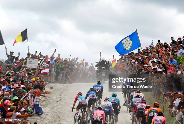 General view of the peloton passing through a gravel strokes sector while fans cheer during the 111th Tour de France 2024, Stage 9 a 199km stage from...