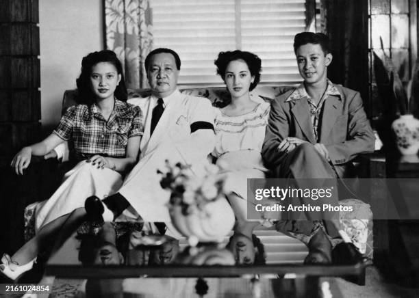 Filipino First Lady Victoria Quirino, wearing a plaid short-sleeve shirt, beside her father, Filipino politician and lawyer Elpidio Quirino,...