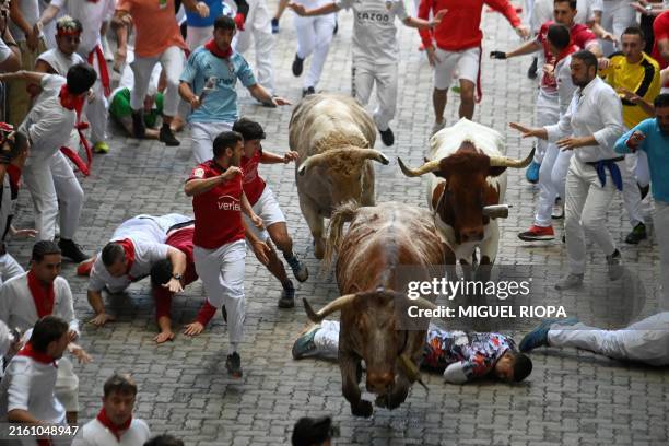 Participants run ahead of Jandilla fighting bulls during the sixth bull run of the San Fermin festival in Pamplona, northern Spain, on July 12, 2024....
