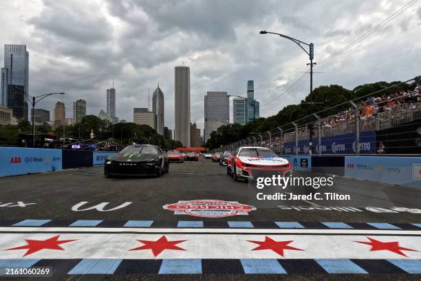 Kyle Larson, driver of the Valvoline Chevrolet, and Ty Gibbs, driver of the Monster Energy Toyota, lead the field on a pace lap prior to the NASCAR...
