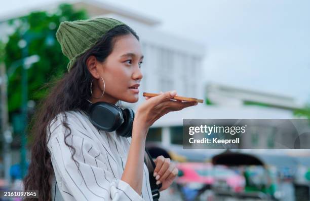 asiatische frau, die ki-apps zum rufen von taxis verwendet - übersetzung stock-fotos und bilder