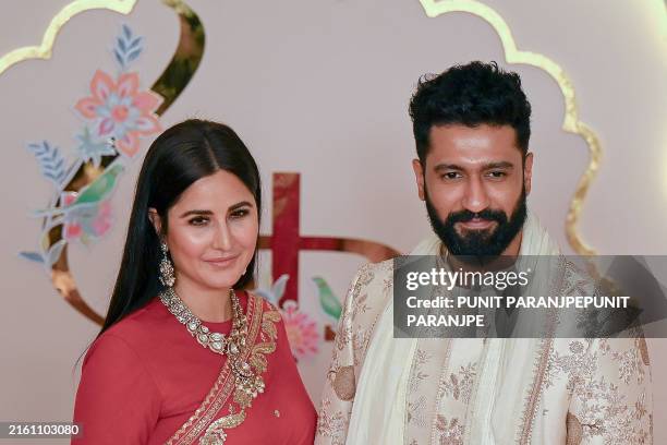 Bollywood actor Vicky Kaushal with his wife and actress Katrina Kaif pose for photos as they arrive to attend the wedding ceremony of billionaire...