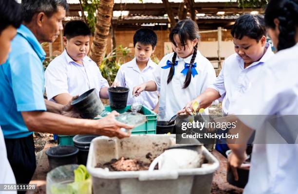 male teacher teaching school children about gardening - horta escolar imagens e fotografias de stock