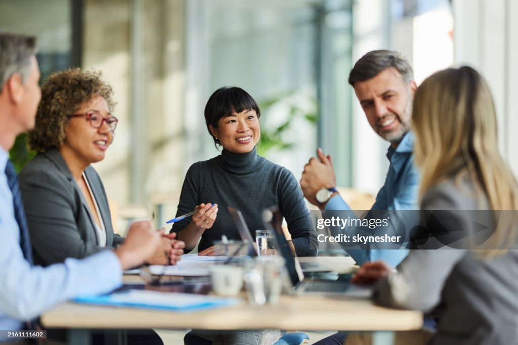 Happy multiracial business team talking on a meeting in the office.