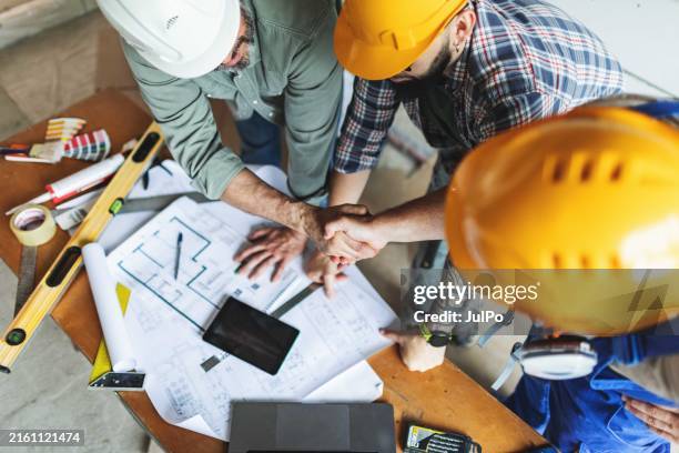 home owner shaking hands with construction worker - contracting stock pictures, royalty-free photos & images