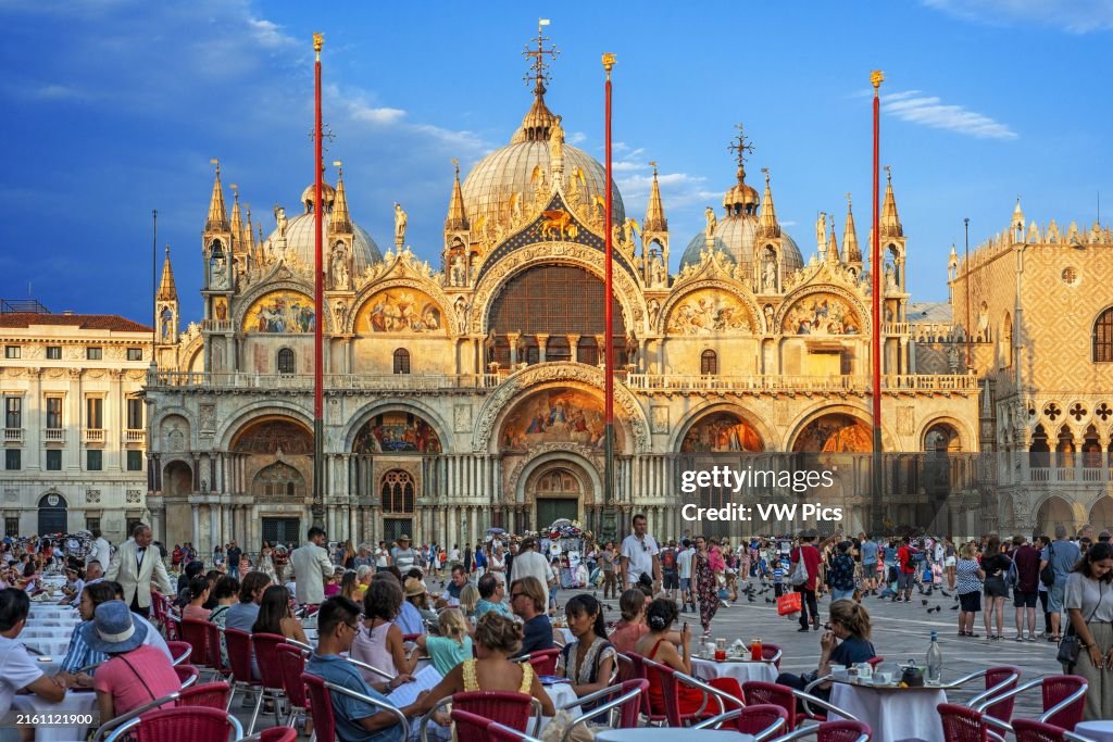 Basilica San Marco reflected in acqua alta in Piazza San Marco at twilight during sunset