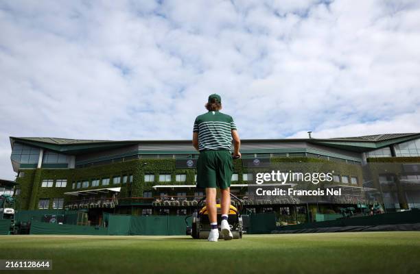 Member of the ground staff prepares the courts ahead of play during day eight of The Championships Wimbledon 2024 at All England Lawn Tennis and...