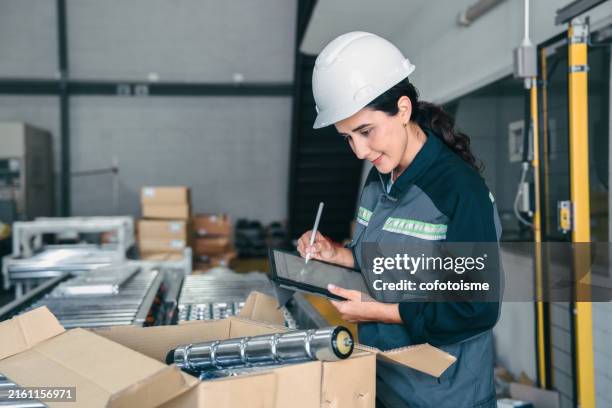 female engineer is working with an automatic roller conveyor system in the factory. - execution stock pictures, royalty-free photos & images