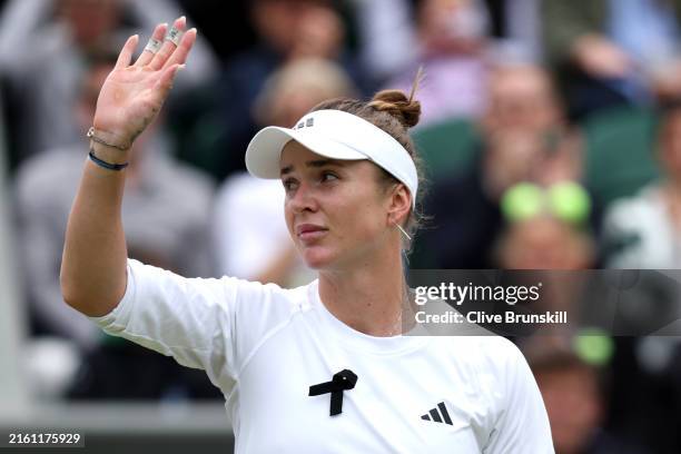 Elina Svitolina of Ukraine acknowledges the crowd as she celebrates match point while wearing a black ribbon in support of Ukraine in the Ladies'...