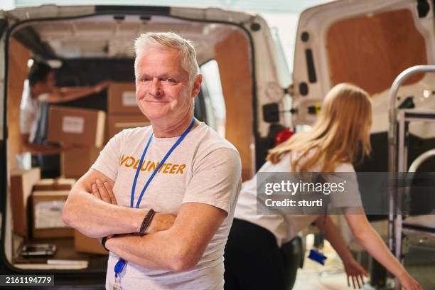 retired volunteer co-ordinating food parcel deliveries - charitable foundation stock pictures, royalty-free photos & images