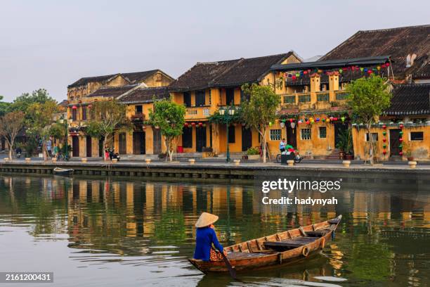 vietnamese woman riding a boat, old town in hoi an city, vietnam - hoi an stockfoto's en -beelden