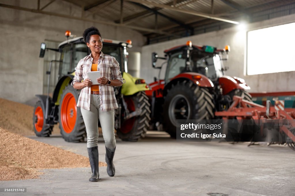 Portrait Of Female Agricultural Worker On Farm Using Digital Tablet