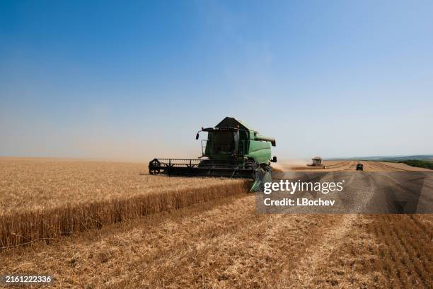 combine harvesters harvests wheat fields - tractor tank stock pictures, royalty-free photos & images