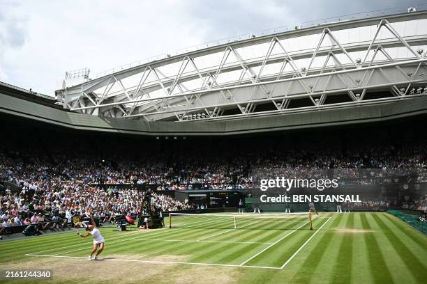 Italy's Jasmine Paolini serves under the open roof of Centre Court, against Czech Republic's Barbora Krejcikova during their women's singles final...