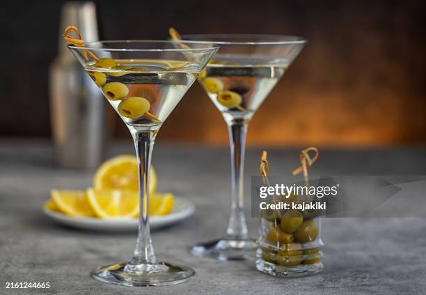 dos copas de martini con aceitunas - vaso de martini fotografías e imágenes de stock
