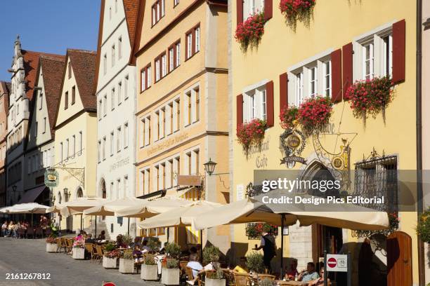 Umbrellas Over Tables Along The Street At The Marketplace; Rothenburg Ob Der Tauber Bavaria Germany.