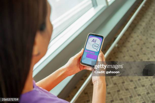 woman chatting with ai chatbot using smartphone - virtual assistant stock pictures, royalty-free photos & images