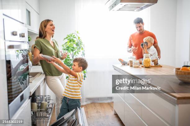 family joy in a new apartment, washing dishes together with a smile - poetshulp stockfoto's en -beelden