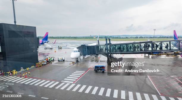 airplane parked at gate with boarding bridge at gdansk airport. - passenger boarding bridge stock pictures, royalty-free photos & images