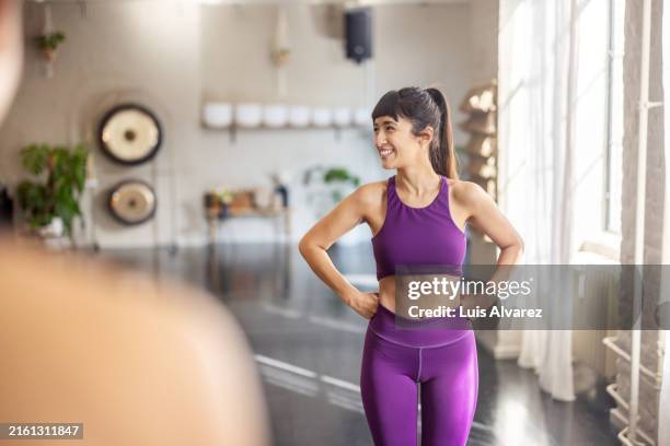 happy young woman standing at yoga class - yoga teacher stock pictures, royalty-free photos & images