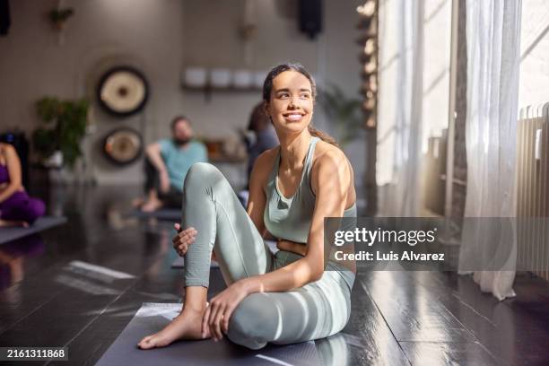 fit woman resting after yoga workout at a yoga class - actividades y técnicas de relajación fotografías e imágenes de stock