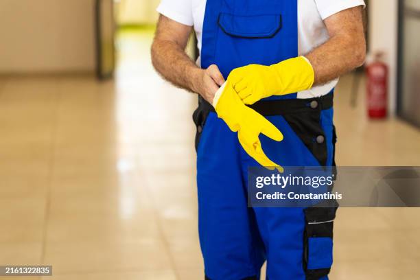 inriconoscibile anziano caucasico maschio bidello indossare un giallo guanti da lavaggio - impresa di pulizie foto e immagini stock