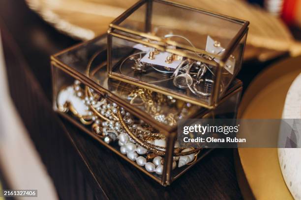 jewelry in boxes and a goldish leaf shape tray on a table. - portagioie foto e immagini stock