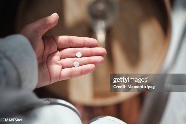 morning after pill. hand holding pills, close up cropped image - taking pills stock pictures, royalty-free photos & images