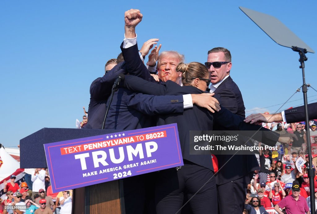 Donald Trump R Former president Donald Trump raises his arm with blood on his face ...