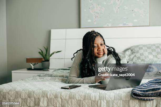 a teen using a mobile finance app to track spending and save money - financial literacy stock pictures, royalty-free photos & images