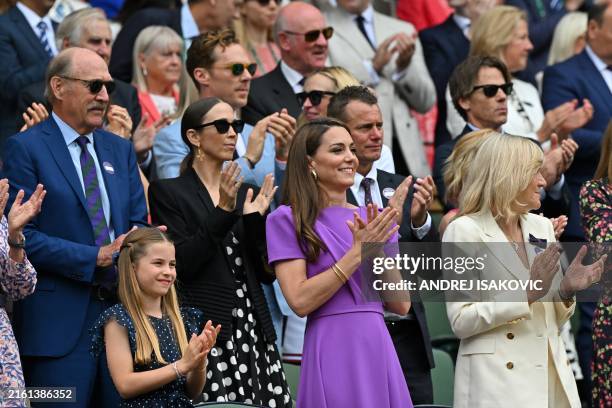 Britain's Catherine, Princess of Wales and her daughter Britain's Princess Charlotte of Wales applaud the players from the Royal Box on Centre Court...