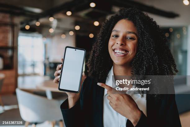 young business woman showing cell phone - tonen stockfoto's en -beelden