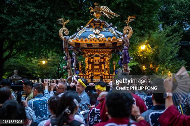 Portable shrine , or "mikoshi", is carried past thousands of lanterns on display on the second day of the four-day Mitama Matsuri, one of the...