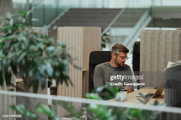 moderner geschäftsmann, der in modernen büroräumen arbeitet - büro stock-fotos und bilder