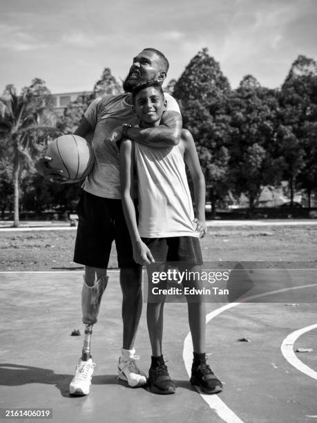 happy indian boy and father standing at basketball court - black and white basketball court stock pictures, royalty-free photos & images