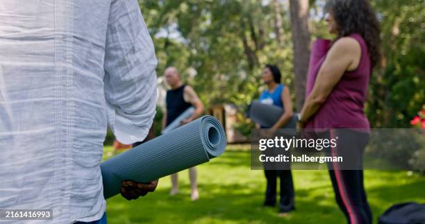 low shot of rehab residents standing in a circle before yoga session - rehabilitation center stock pictures, royalty-free photos & images