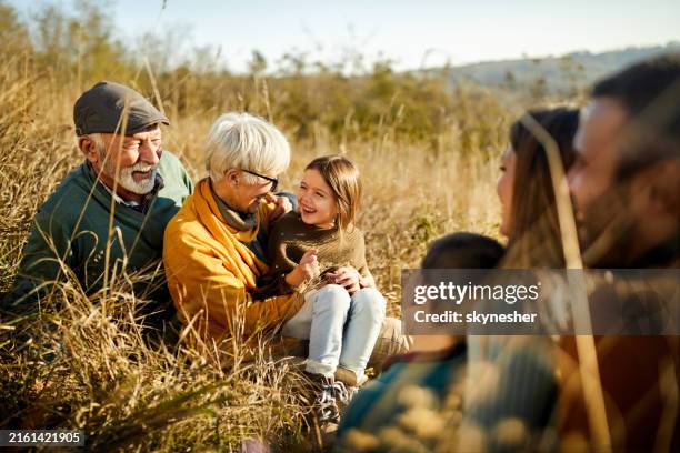 feliz familia extendida disfrutando en un día de otoño en una colina. - familia multigeneracional fotografías e imágenes de stock