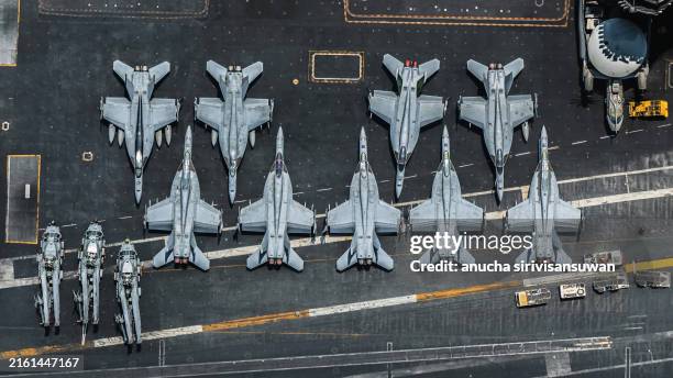 f/a-18e super hornet is parked on an american military aircraft carrier at sea. - abwehr stock-fotos und bilder