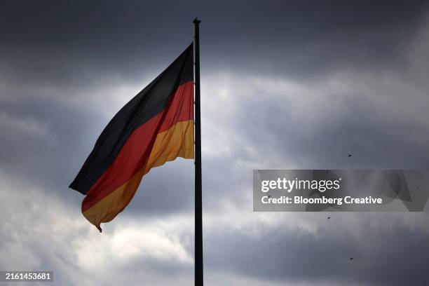 a german flag under a moody sky - duitse vlag stockfoto's en -beelden