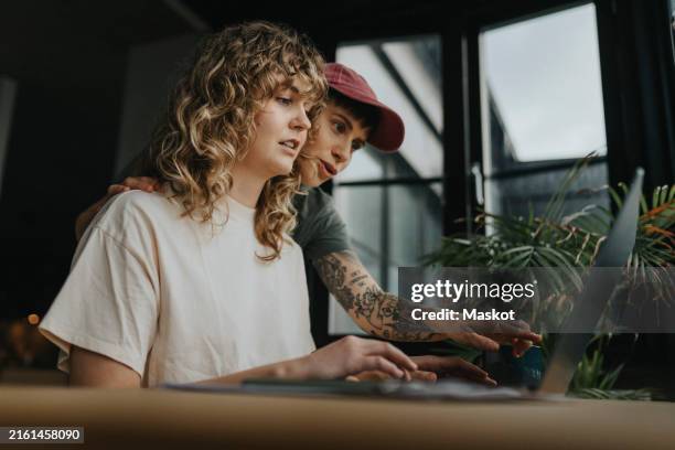 lesbian business partners working together on laptop at home - lesbiana fotografías e imágenes de stock
