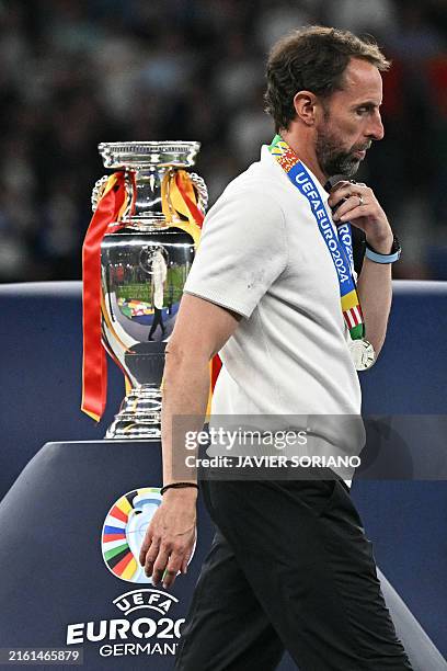 England's head coach Gareth Southgate walks with his silver medal past to the trophy after the UEFA Euro 2024 final football match between Spain and...