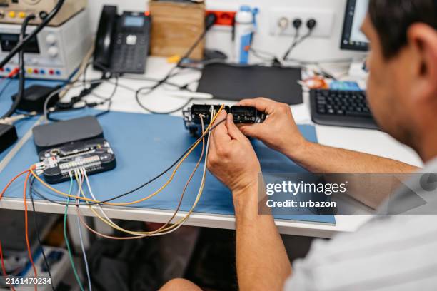 car mechanic working on an engine control unit in his office workshop - screen replacement stock pictures, royalty-free photos & images