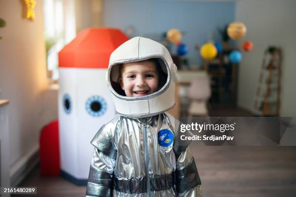 portrait of a preschool boy in a space suit playing at home, imagining space travel. - roupa de astronauta imagens e fotografias de stock