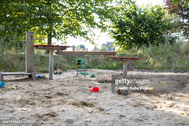 empty playground. sandpit with plastic toys on the empty playground - zandbak stockfoto's en -beelden