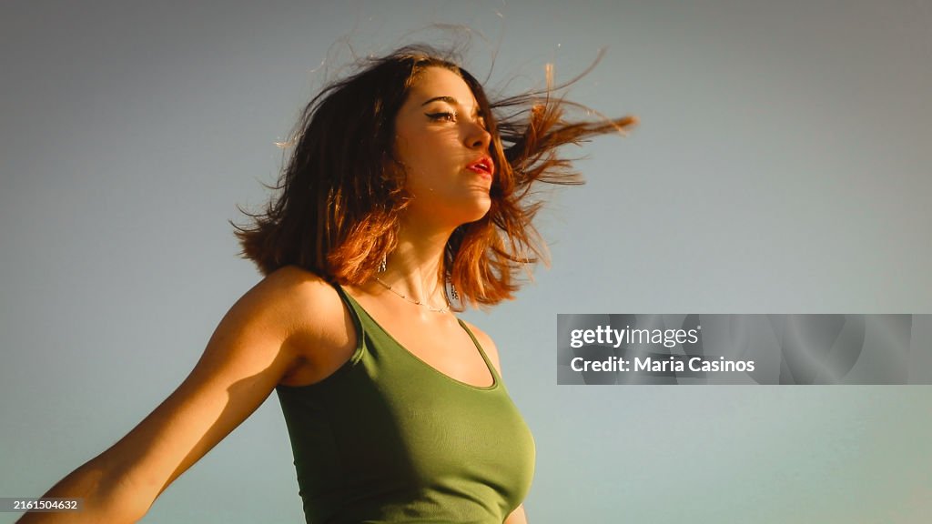 Beautiful young woman breathing with her hair in the wind
